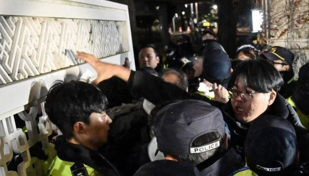 Polisi menahan massa yang memaksa masuk gedung Majelis Nasional di Seoul, Korea Selatan, Selasa (3/12/2024), setelah Presiden Yoon Suk Yeol mengumumkan darurat militer.(AFP/JUNG YEON-JE)